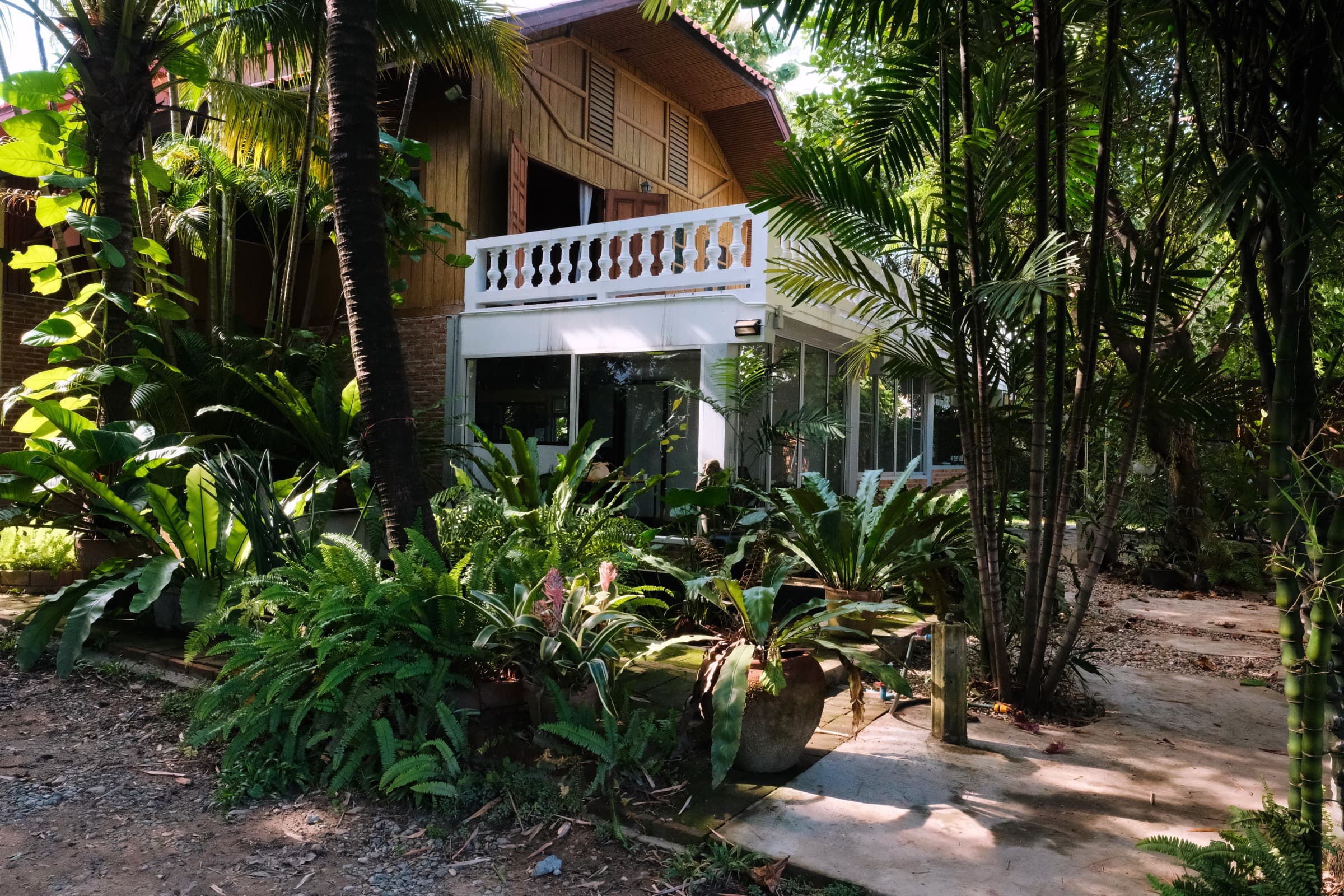Ada House CNX — a traditional Thai wooden house surrounded by a tropical garden in Chiang Mai
