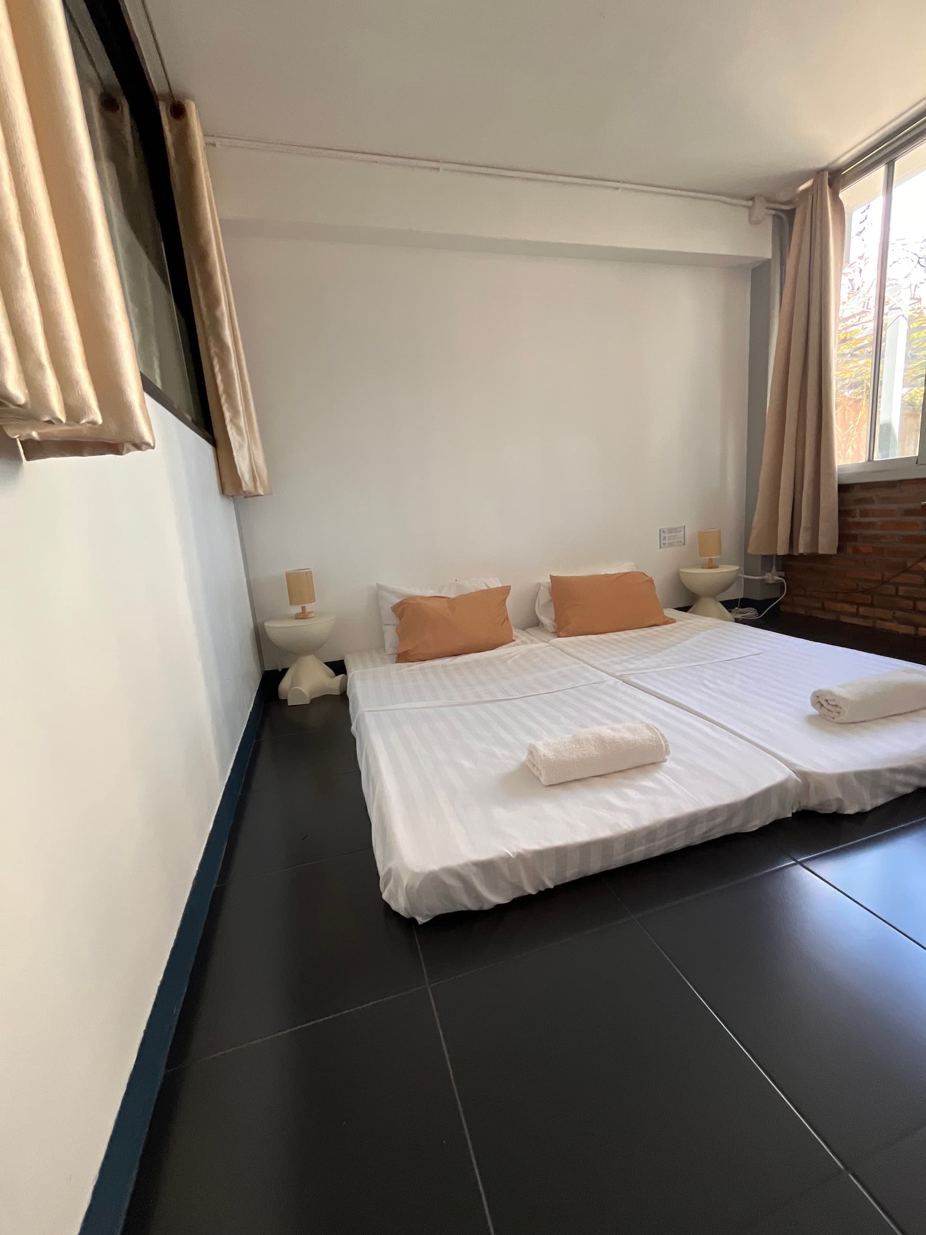 Ground floor room with queen bed and wooden desk facing terrace