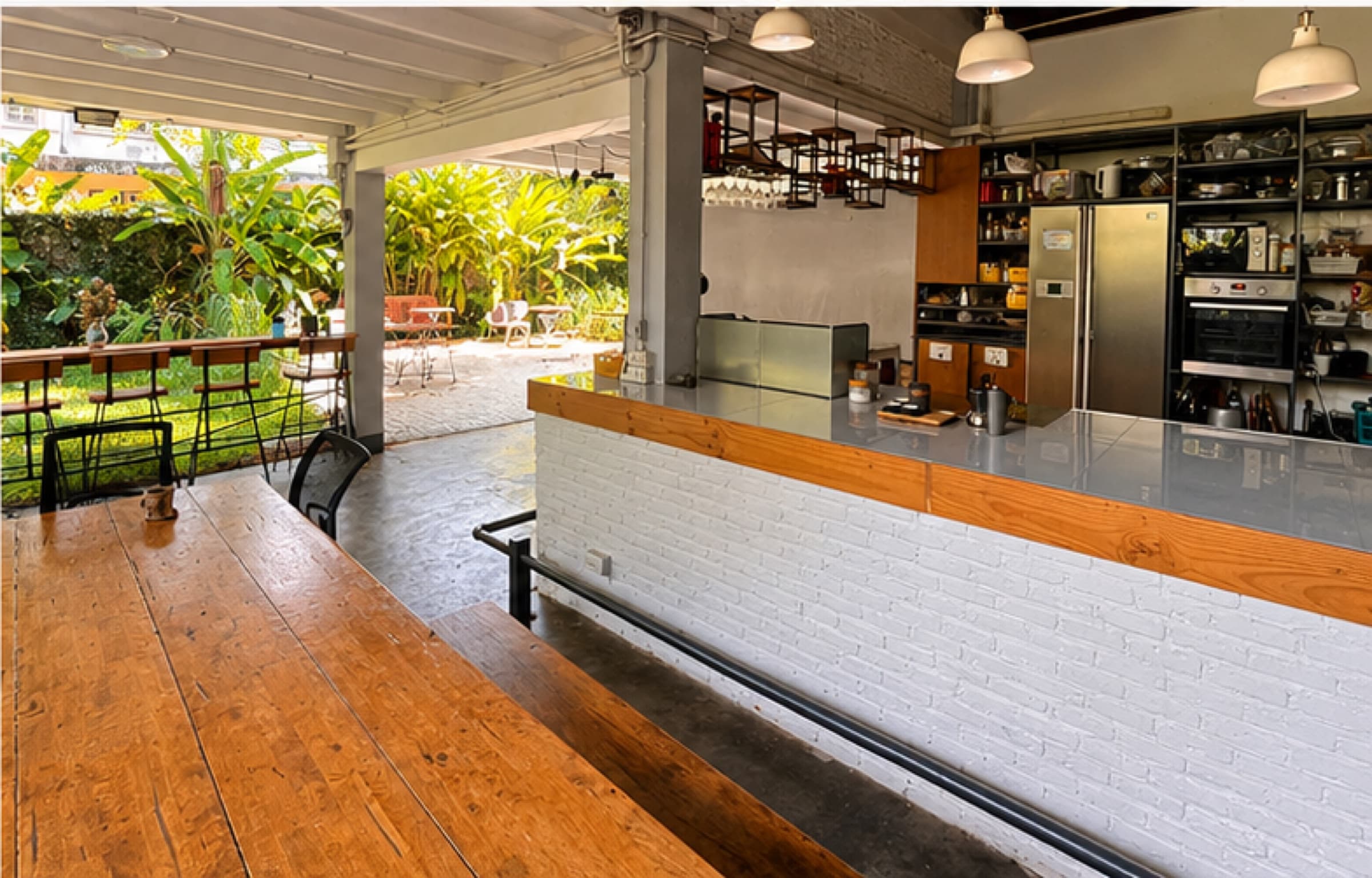 Downstairs covered kitchen and bar opening onto the garden under wooden beam ceiling